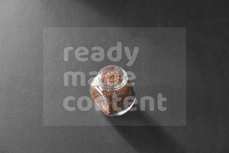 حبوب الكتان في وعاء زجاجي علي خلفية سوداء