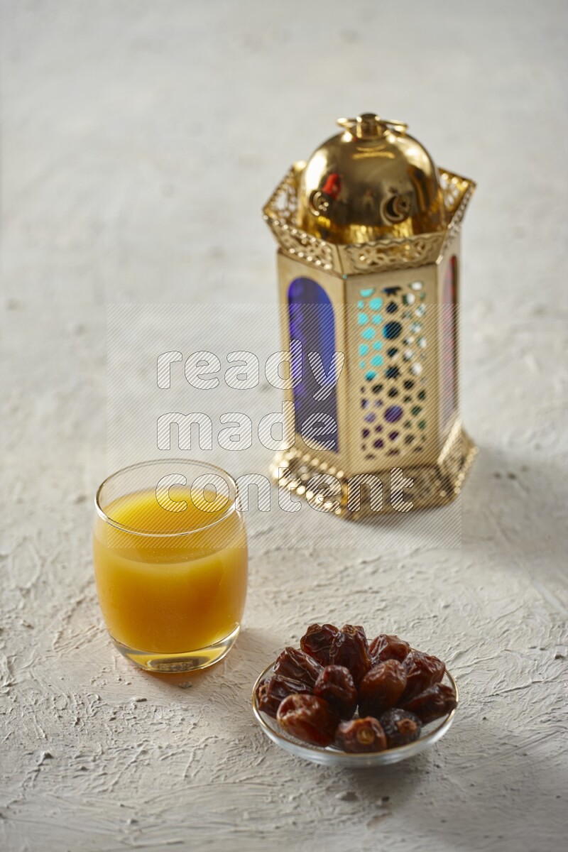 A golden lantern with different drinks, dates, nuts, prayer beads and quran on textured white background