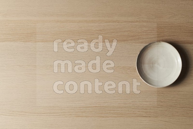 Top View Shot Of A Beige Pottery Plate on Oak Wooden Flooring