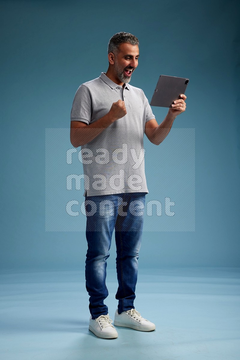 Man Standing working on tablet on blue background