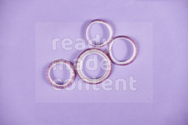 Red onions rings on purple background