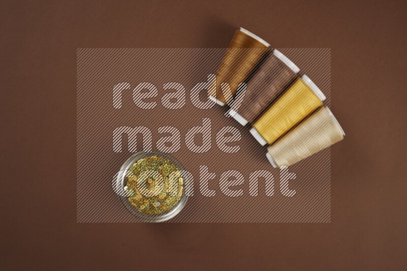A yellow collection of sewing and tailoring tools arranged on a brown background