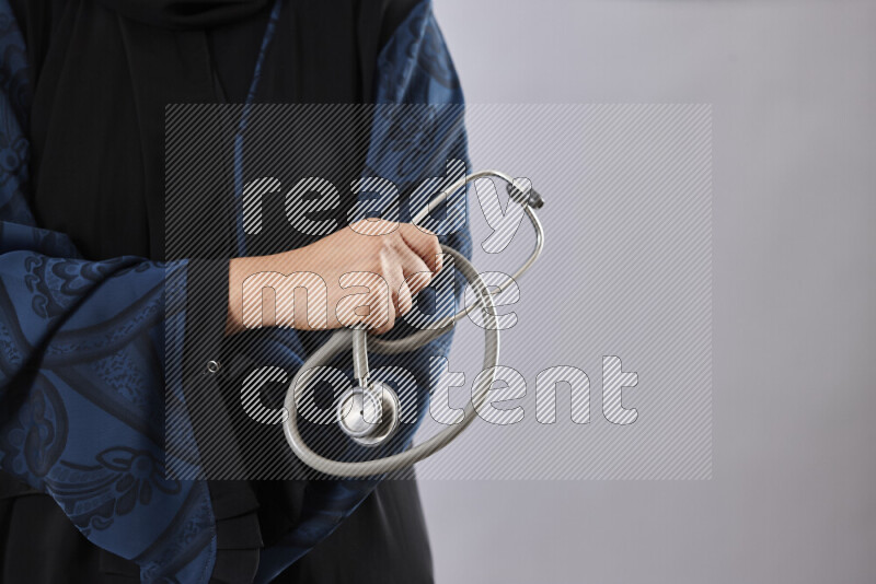 Female doctor wearing an abaya and medical attire in different positions