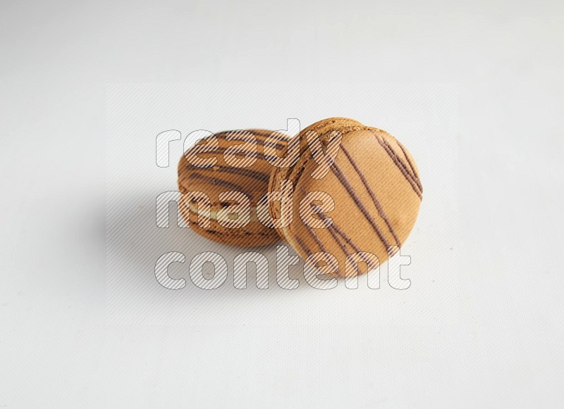 45º Shot of two light brown  Almond Cream macarons on white background