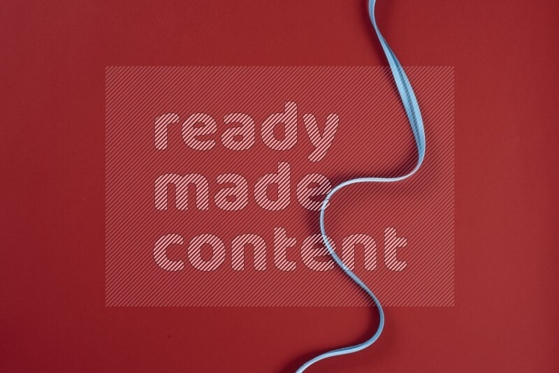 مجموعة من أدوات الخياطة والتفصيل زرقاء وحمراء اللون على خلفية حمراء