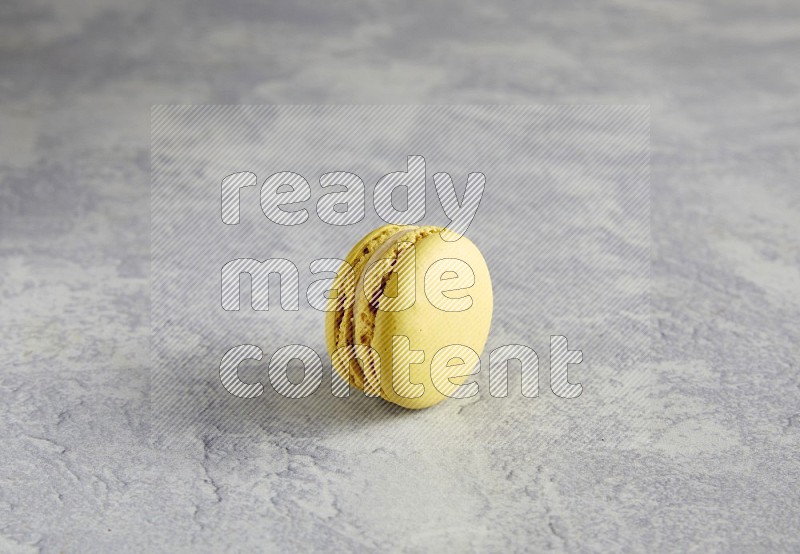 45º Shot of Yellow Lime macaron on white marble