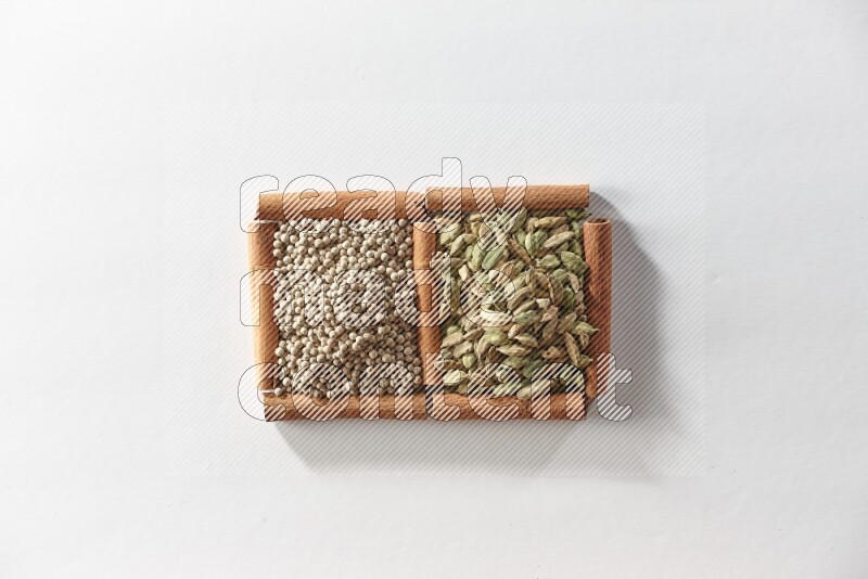 2 squares of cinnamon sticks full of cardamom and white pepper on white flooring