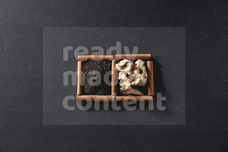 2 squares of cinnamon sticks full of dried ginger and black tea on black flooring