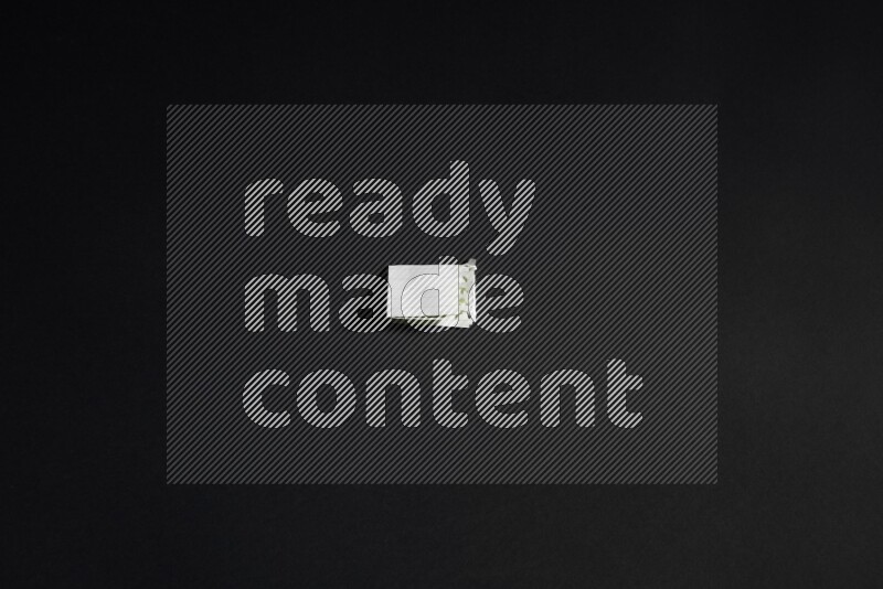 Folded notebook sheet on black background