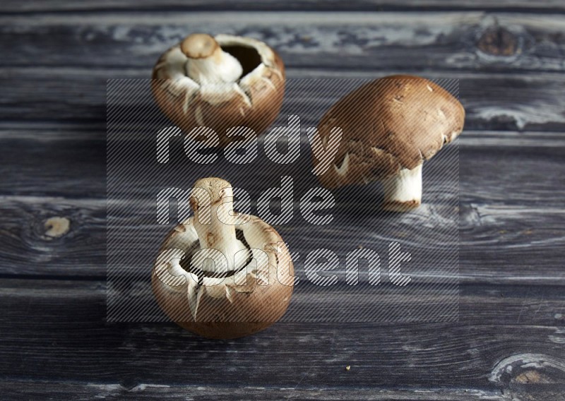 45 degree Cremini  mushrooms on a textured grey background