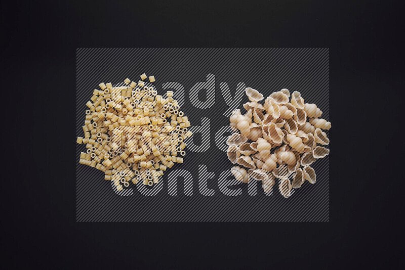 Different pasta types in bunches on black background