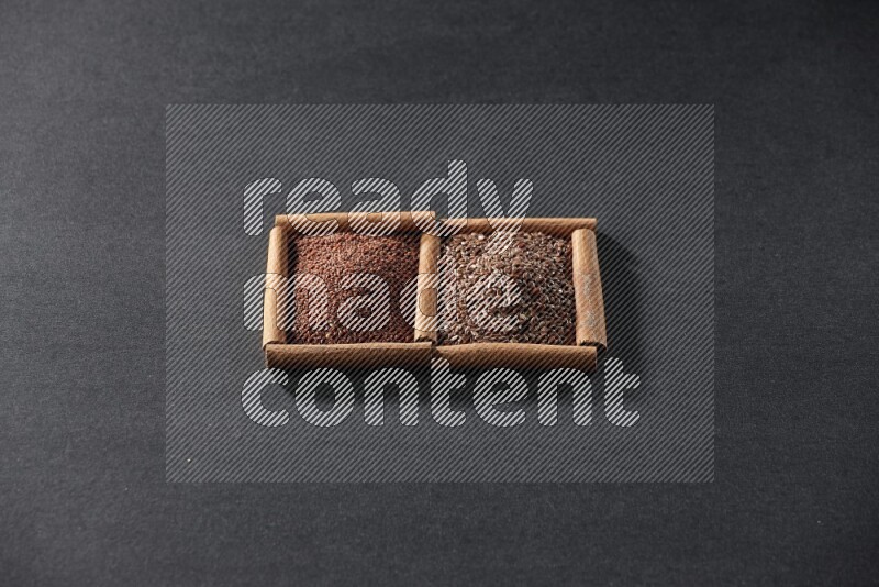 2 squares of cinnamon sticks full of garden cress and flaxseeds on black flooring