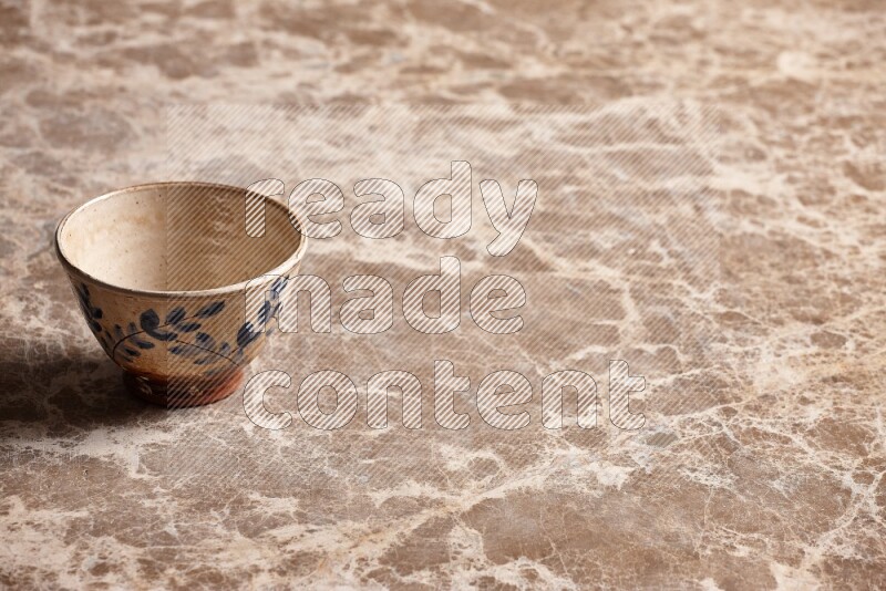 A decorative pottery bowl on beige marble background