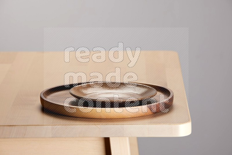 multi-colored pottery Plate placed on a light colored wooden tray on the edge of wooden table