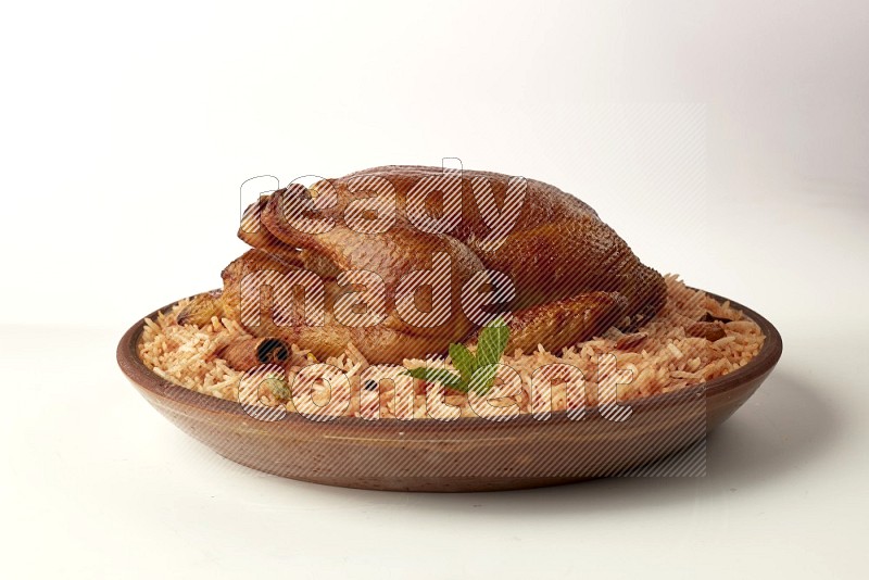 red basmati Rice with whole roasted chicken on a pottery plate direct on white background