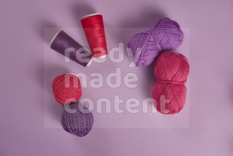 A pink and purple collection of sewing and tailoring tools arranged on a purple background