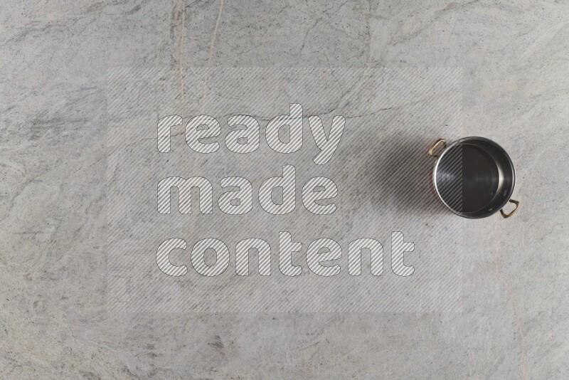 A small copper pot on grey marble background