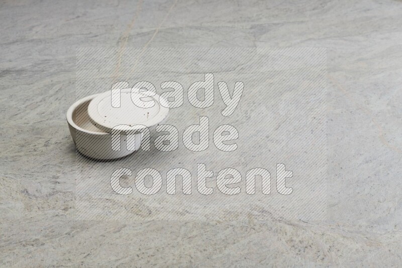 A white pottery bowl on grey marble background