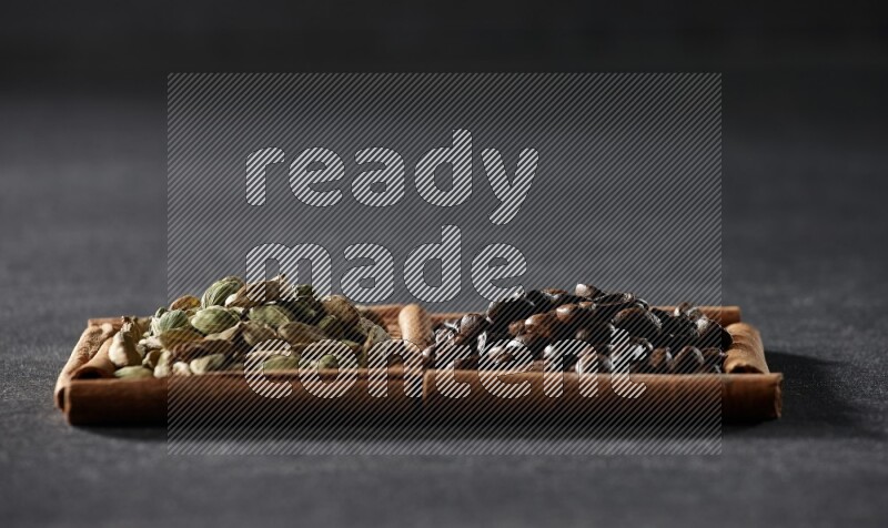 2 squares of cinnamon sticks full of coffee beans and cardamom on black flooring