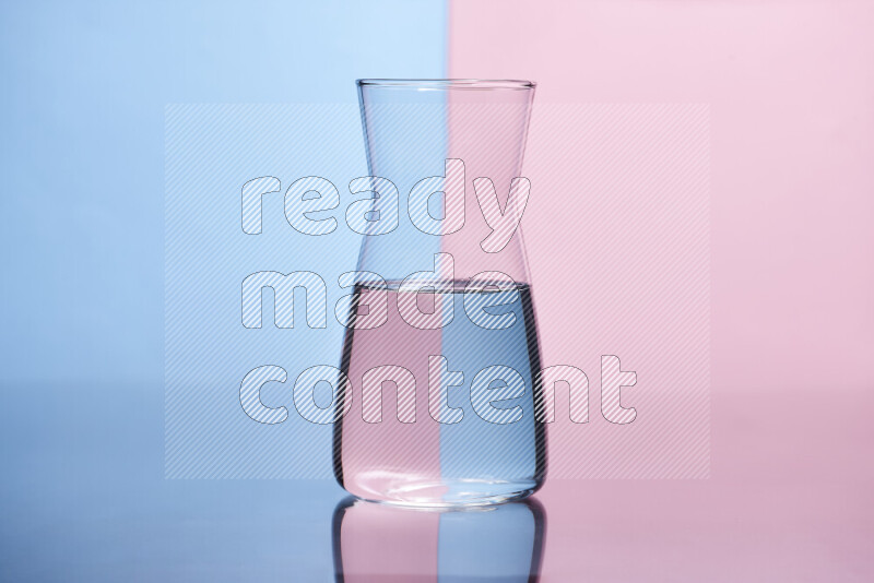 The image features a clear glassware filled with water, set against light blue and rose background