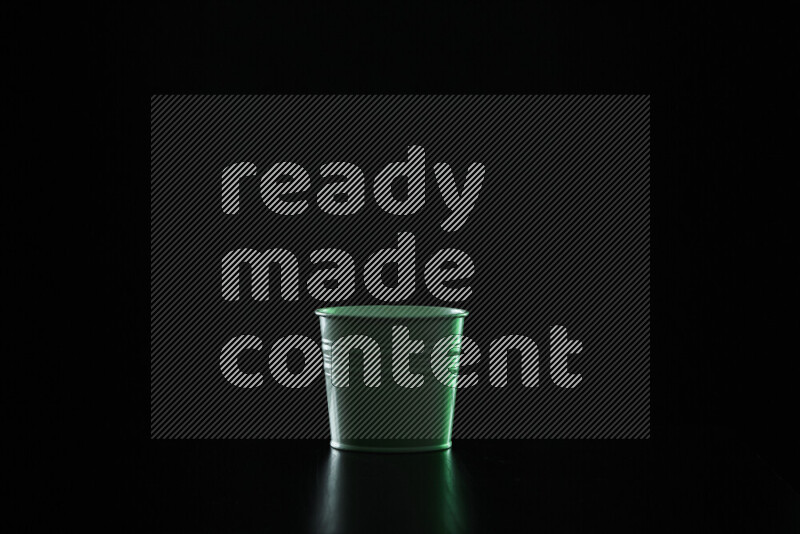 A plant pot with colored rim light against black background