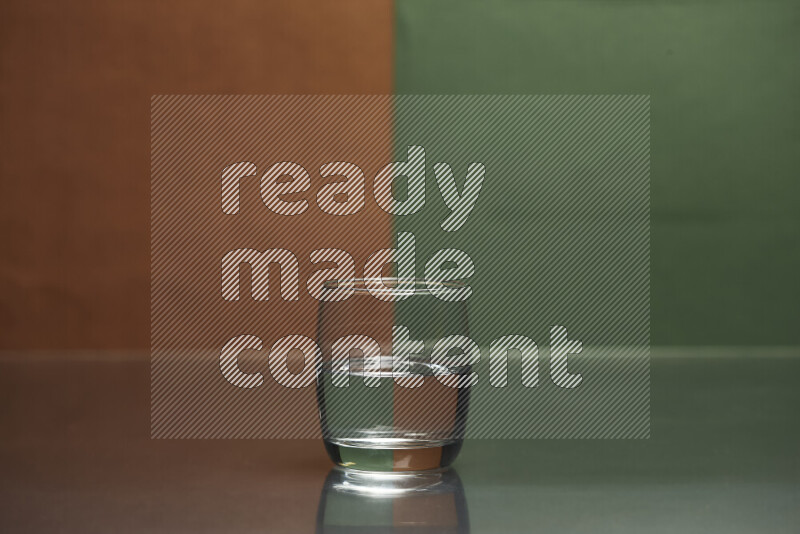 The image features a clear glassware filled with water, set against brown and dark green background