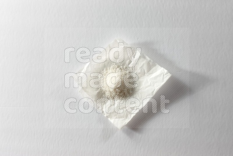 Desiccated coconut on a piece of paper on a white background in different angles