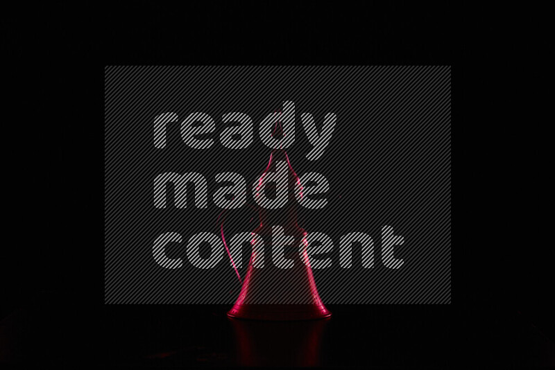 A turkish coffee pot with colored rim light against black background