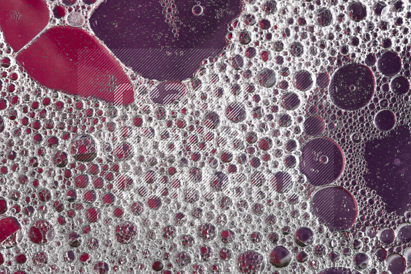 لقطات مقربة لفقاعات الصابون وقطرات الماء على خلفية وردية وأرجوانية