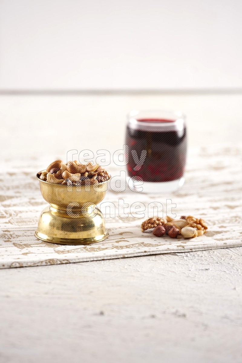 Nuts in a metal bowl with hibiscus in a light setup