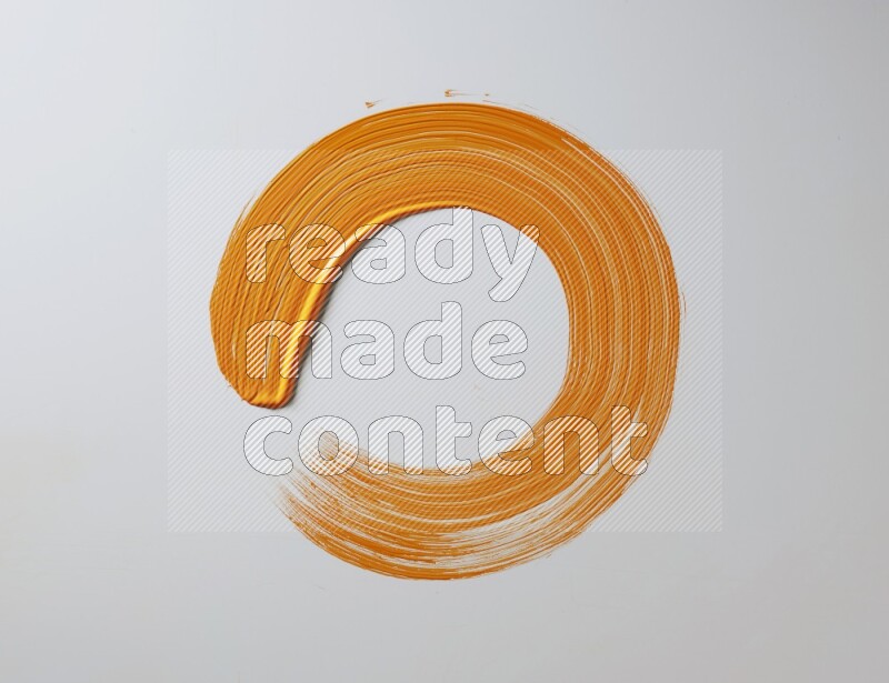 An orange circular painting brush stroke on white background