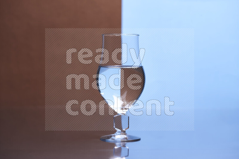 The image features a clear glassware filled with water, set against brown and light blue background