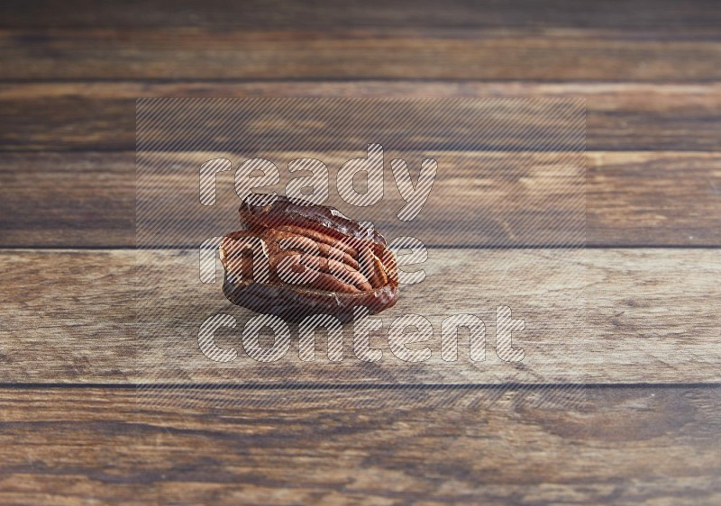 pecan stuffed madjoul date on a wooden background