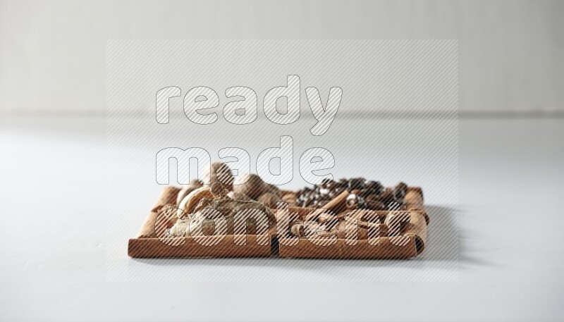 4 squares of cinnamon sticks full of coffee beans, nutmeg, cinnamon and dried ginger on white flooring