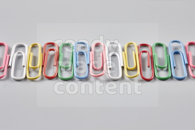 Multicolored paperclips isolated on a grey background