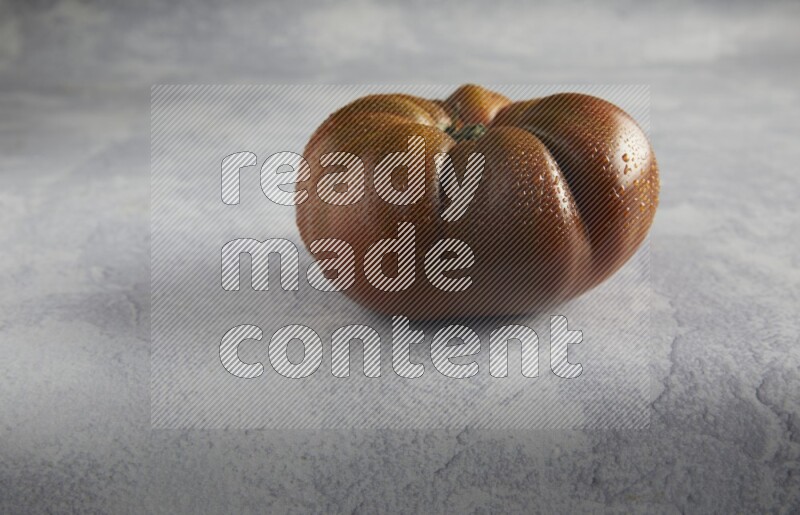 45 degree single heirloom tomato on a light blue textured background