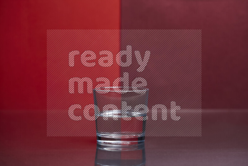 The image features a clear glassware filled with water, set against red and dark red background