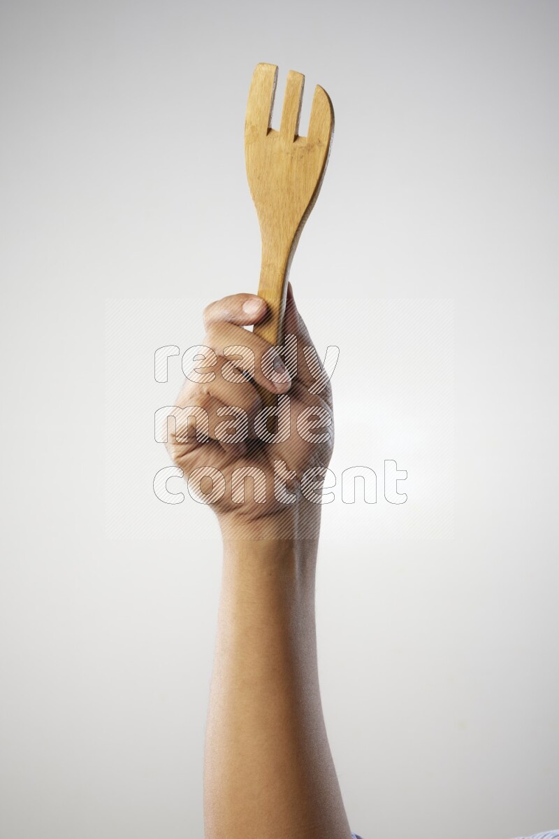 Male Hand Holding Wooden Fork on white  background