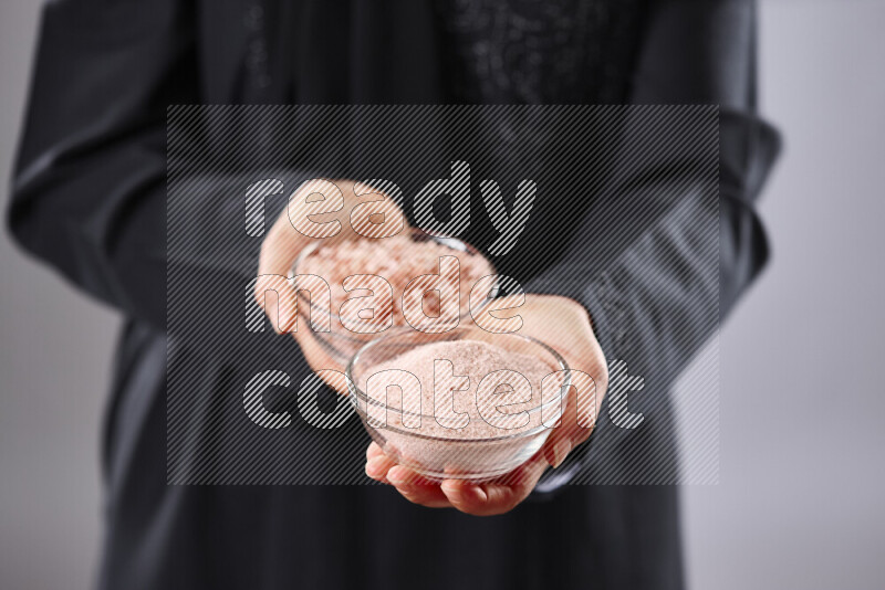 امرأة ترتدي عباءة تحمل أنواع مختلفة من البهارات في أوضاع متعددة