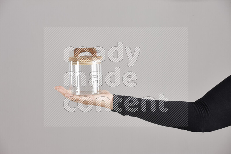 امرأة ترتدي عباءة سوداء تحمل أدوات زجاجية مختلفة في أوضاع متعددة