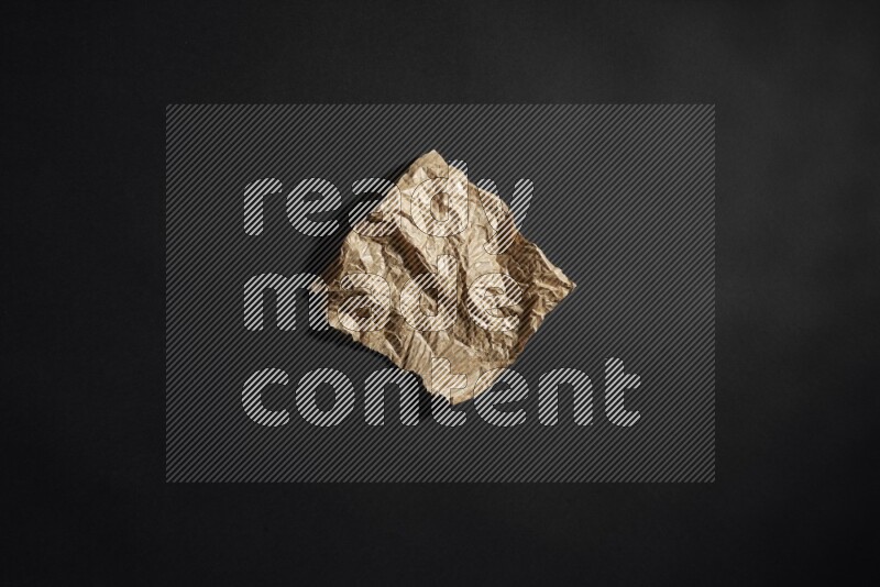 Crumpled craft paper on black background