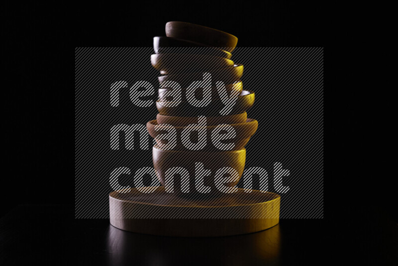 Wooden kitchen essentials with colored rim light against black background