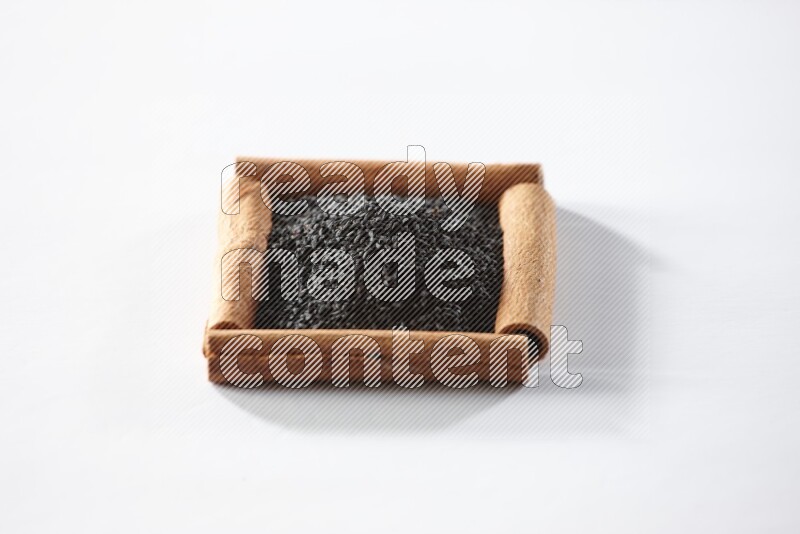 A single square of cinnamon sticks full of black seeds on white flooring