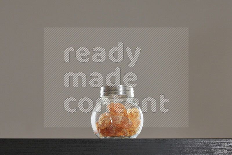 Gum arabic in a glass jar on black background