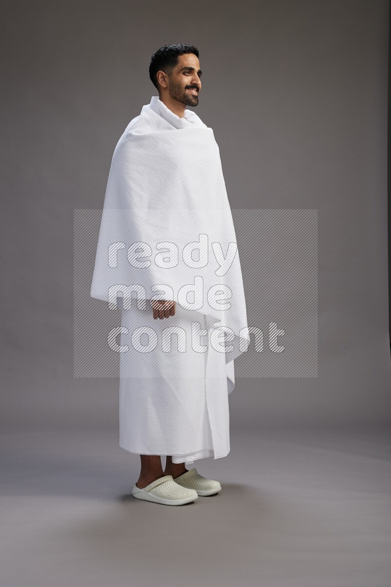 A man wearing Ehram Standing Interacting with the camera on gray background