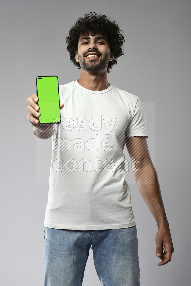 A man wearing casual standing and showing a phone screen on white background