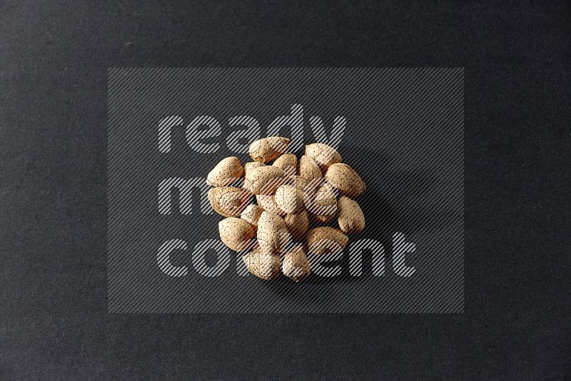 A bunch of almonds on a black background in different angles