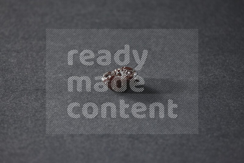 حبة واحدة من البرقوق المجفف على خلفية سوداء