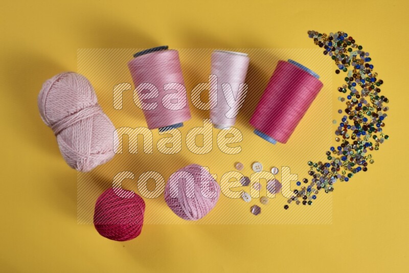 A pink collection of sewing and tailoring tools arranged on a yellow background