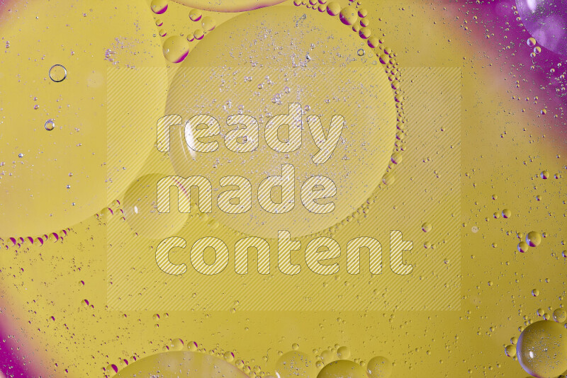 لقطات مقربة لفقاعات من الزيت على سطح الماء باللون الأصفر والوردي